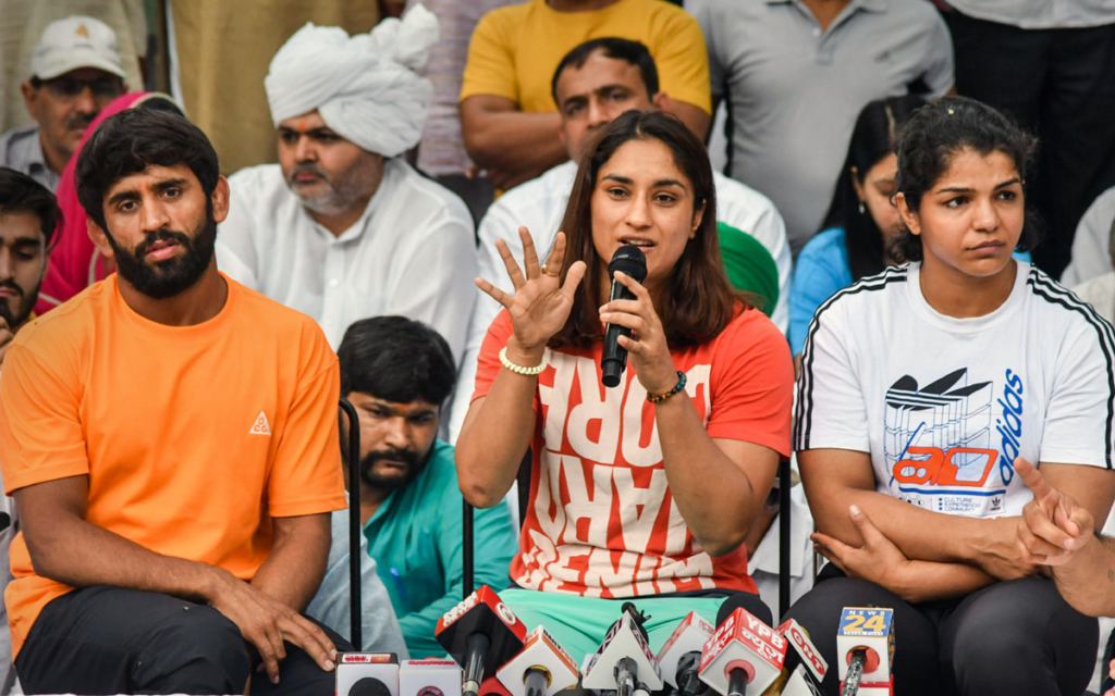 Indian wrestlers including Vinesh Phogat, Bajrang Punia, Sakshi Malik, Satyawart Kaidyan, and Jitender Kinha protest against WFI Chief Brij Bhushan Singh on the 18th day of their protest wearing black bands. The wrestlers are demanding the arrest of the WFI chief on charges of sexually exploiting female wrestlers, including one underage. 