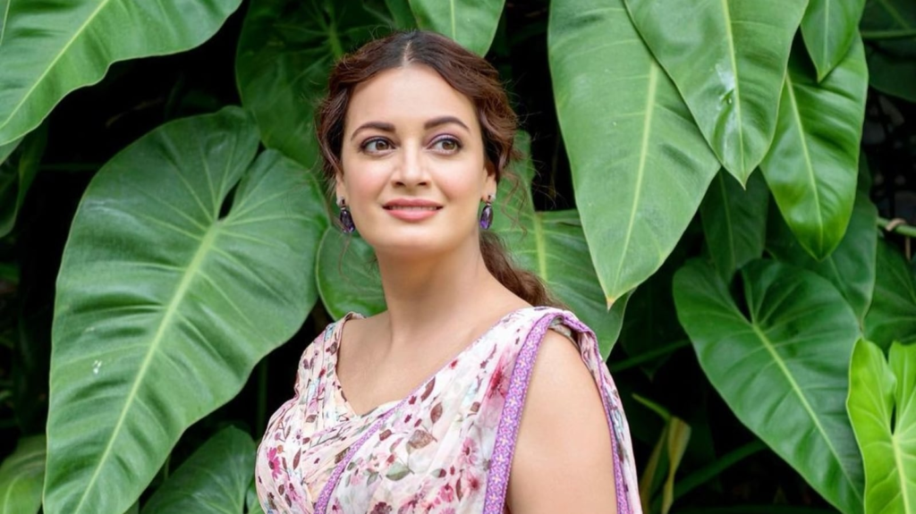 Bollywood actress Dia Mirza turns heads in an elegant eco-friendly black dress from designer label SAND. See how she perfectly complements her look with golden hoops, handwoven beige pumps, and her beautiful natural curly tresses.