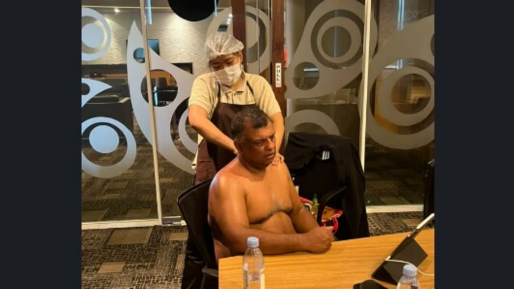 "AirAsia's Tony Fernandes faces backlash for an unusual management meeting scene, sitting shirtless while getting a massage."
